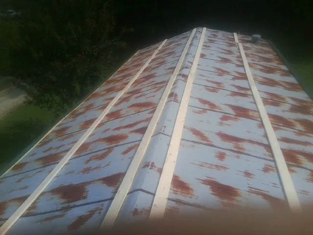 Rusted metal roof panels with new wood purlins before replacement — Storm Damage Roof Repair in Wade by Roofing Brothers