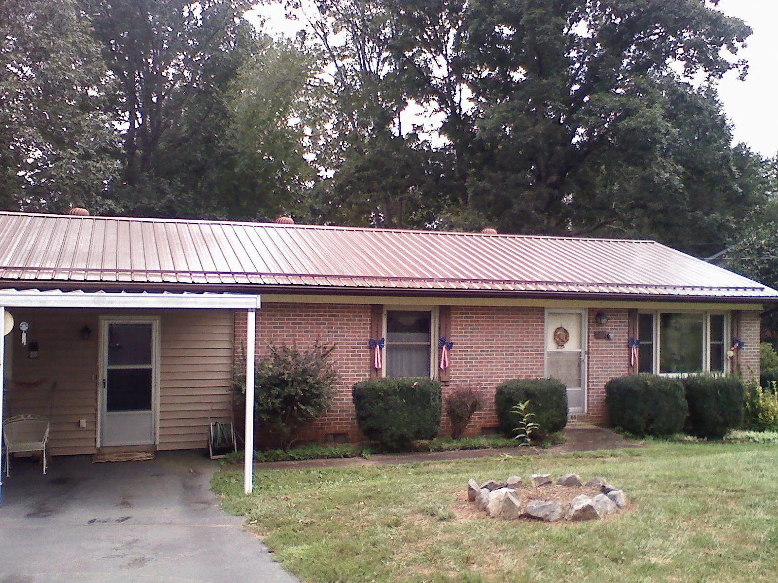 Bronze metal roof and carport on a brick ranch home — Roof Repair work by our crew in Wade